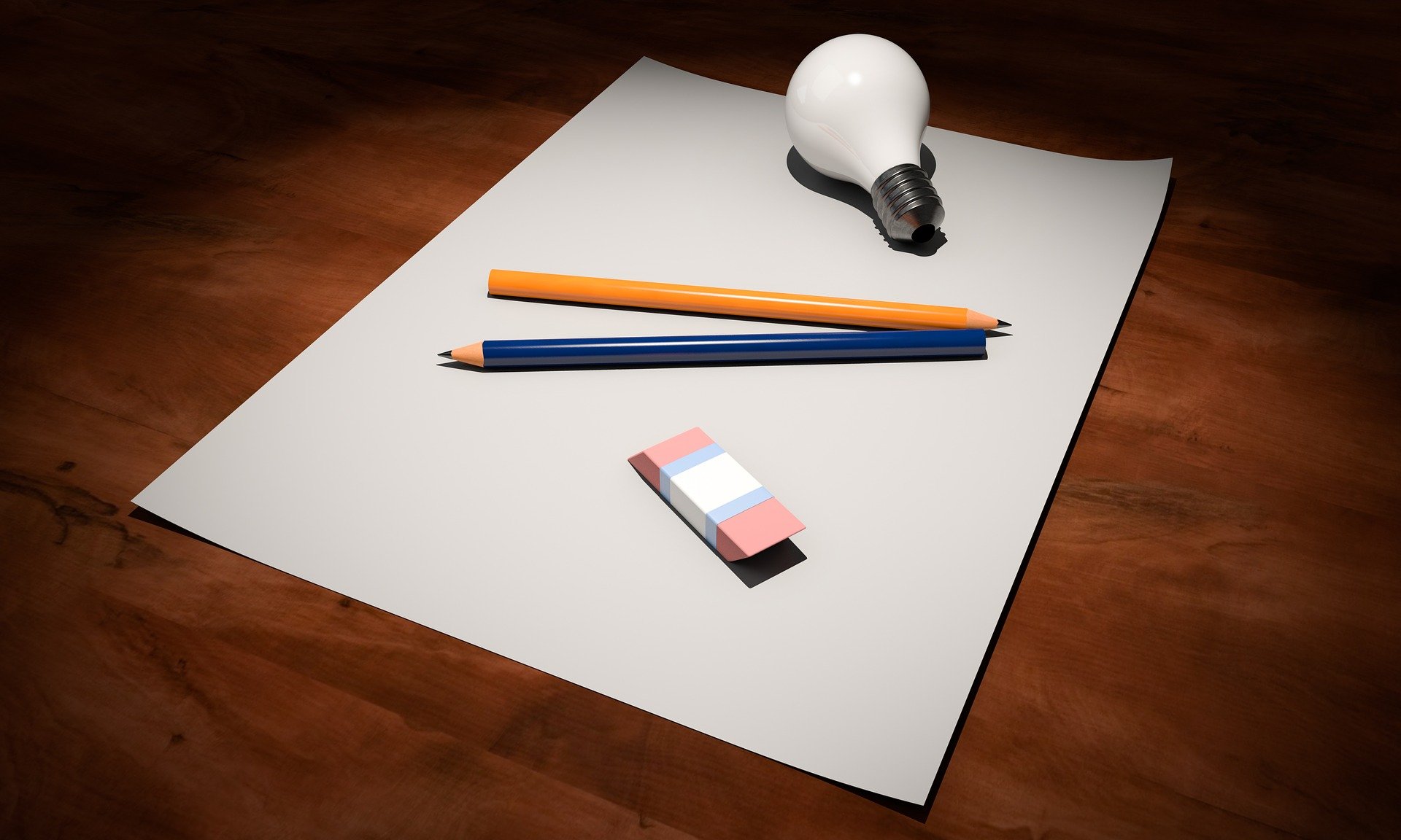 A light bulb, pencils, and paper